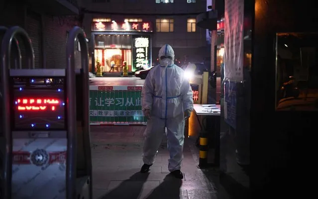 A security guard wears protective clothing as a preventive measure against the COVID-19 coronavirus as he stands at the entrance of a restaurant in Beijing on February 25, 2020. China on February 25 reported another 71 deaths from the novel coronavirus, the lowest daily number of fatalities in over two weeks, which raised the toll to 2,663. (Photo by Greg Baker/AFP Photo)