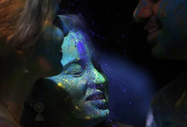 A woman's face is smeared with colored powder during celebrations marking the Holi festival in Mumbai, India, Tuesday, March 10, 2020 (Photo by Rajanish Kakade/AP Photo)