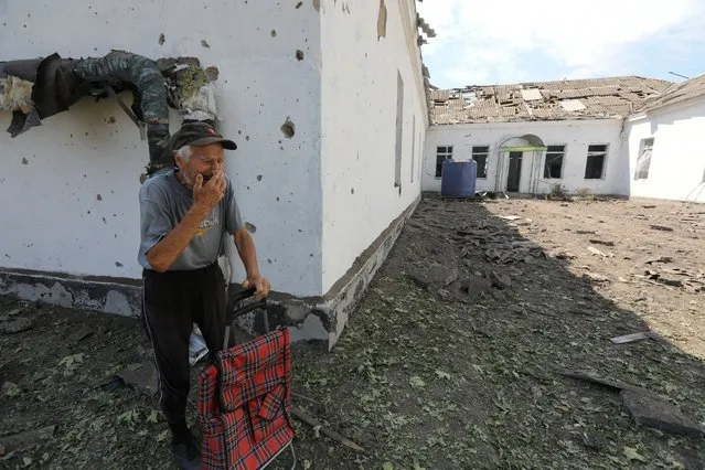 A local resident reacts near a school building damaged by a Russian missile strike, as Russia's attack on Ukraine continues, in Mykolaiv, Ukraine on July 28, 2022. (Photo by Mykola Tymchenko/Reuters)