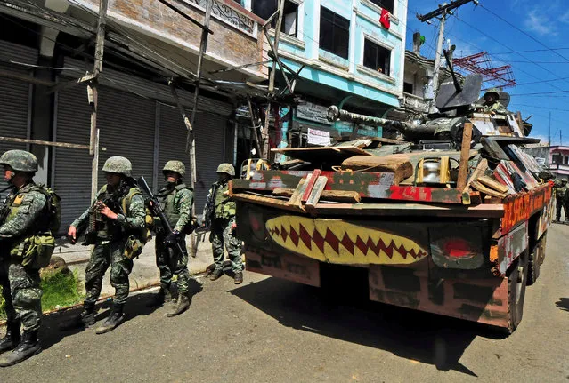 An Armoured Personnel Carrier (APC) and government troops march towards Mapandi bridge after 100 days of intense fighting between soldiers and insurgents from the Maute group, who have taken over parts of Marawi city, southern Philippines August 30, 2017. (Photo by Froilan Gallardo/Reuters)
