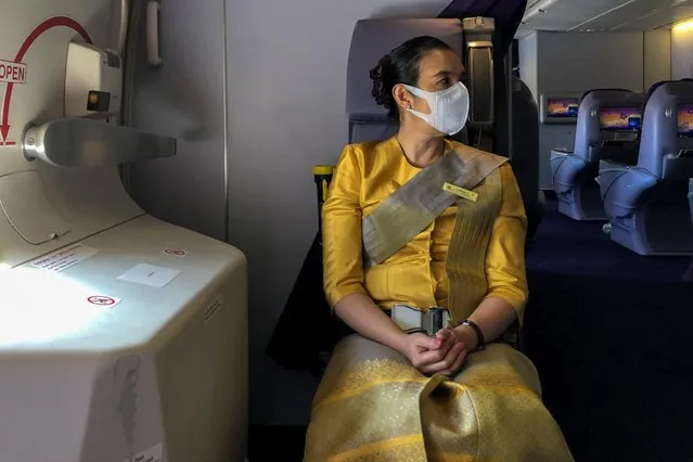 A flight attendant wearing a protective face mask is pictured during a flight from Sydney to Bangkok, February 1, 2020. (Photo by Jorge Silva/Reuters)