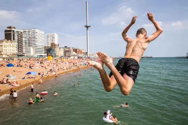 Members of the public enjoy the sunny weather along the Brighton beach in East Sussex, United Kingdom on July 17, 2022. (Photo by Marcin Nowak/London News Pictures)