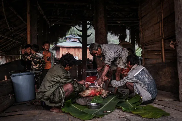 This photo taken on February 7, 2020 shows men preparing a meal after an overnight ceremony by Naga tribeswomen to bless the harvest in Satpalaw Shaung village, Lahe township in Myanmar's Sagaing region. (Photo by Ye Aung Thu/AFP Photo)