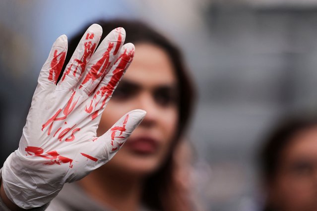 A woman wears a glove with red paint stains as demonstrators protest in solidarity with Palestinians in Gaza, amid the ongoing conflict between Israel and the Palestinian Islamist group Hamas, in Duesseldorf, Germany on October 21, 2023. (Photo by Thilo Schmuelgen/Reuters)