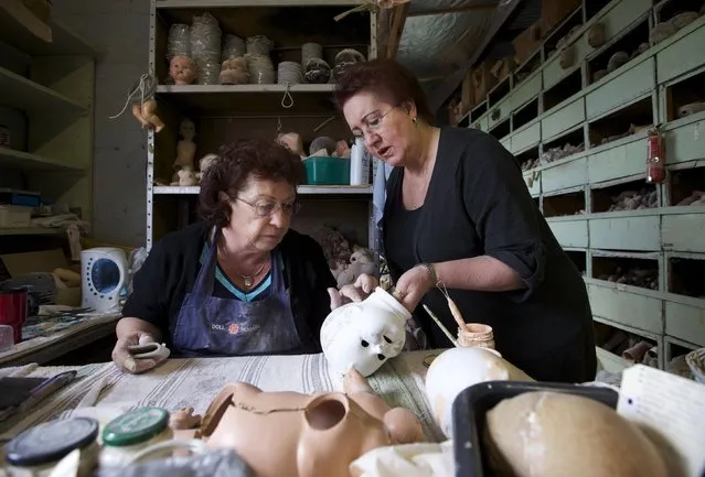 Doll restorers Gail Grainger (L) and Kerry Stuart inspect the head of a composition doll, made from compressed wood chip, in the workshop of Sydney's Doll Hospital, July 15, 2014. Photo by Jason Reed/Reuters)