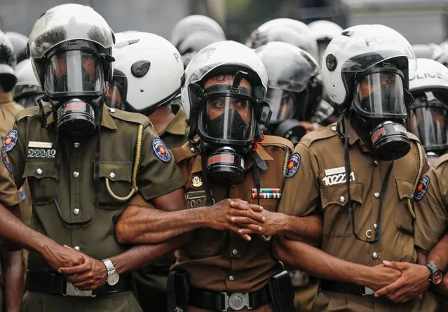 Sri Lankan police officers stand as a human barrier to block demonstrators during an anti-government protest by Inter-University Student's Federation, amid the country's economic crisis, in Colombo, Sri Lanka on August 30, 2022. (Photo by Dinuka Liyanawatte/Reuters)