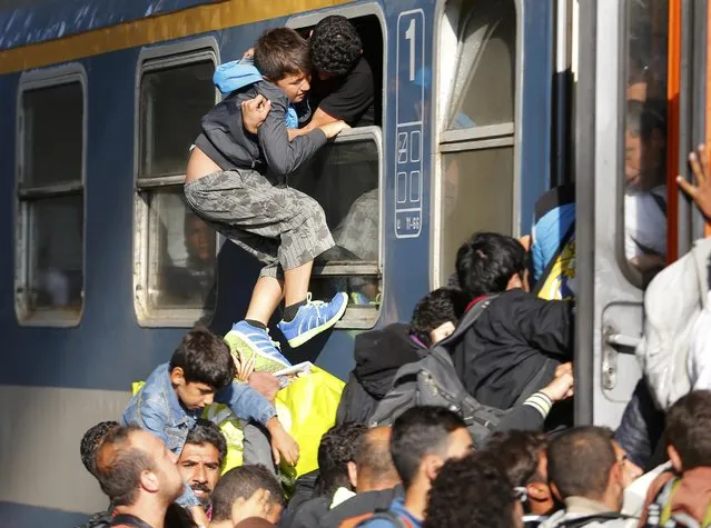Migrants storm into a train at the Keleti train station in Budapest, Hungary, September 3, 2015 as Hungarian police withdrew from the gates after two days of blocking their entry. (Photo by Laszlo Balogh/Reuters)