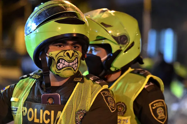 Police officers use face masks as a preventive measure against the spread of the new coronavirus, COVID-19, in Cali, Colombia on March 20, 2020. Colombian authorities announced a mandatory isolation simulation for the extended weekend, from March 21 to 23, as a preventive measure against the spread of the new coronavirus, COVID-19. (Photo by Luis Robayo/AFP Photo)