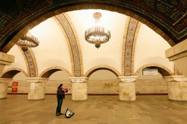 A musician plays violin as he waits for the last train before metro shutdown amid coronavirus (COVID-19) concerns, at Zoloti Vorota station in central Kiev, Ukraine on March 17, 2020. (Photo by Valentyn Ogirenko/Reuters)