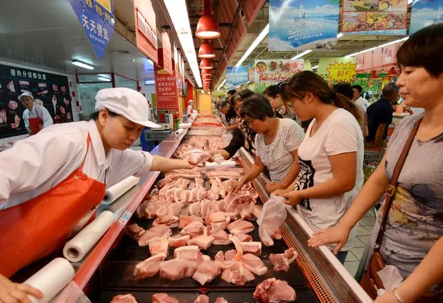 Customers shop for pork at a supermarket in Fuyang, Anhui province, August 9, 2015. Producer prices in China fell to a near six-year low in July while consumer inflation remained subdued, signalling the world's second-largest economy was still facing deflationary pressures and that Beijing has room to further support the sluggish economy. (Photo by Reuters/Stringer)