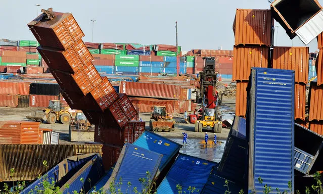 Rescuers and machines clean up damaged shipping containers at the site of Tianjin warehouse explosion on September 8, 2015 in Tianjin, China. The death toll from the massive blasts in Tianjin rose to 161, and 12 people remained missing, officials said. (Photo by ChinaFotoPress/Getty Images)