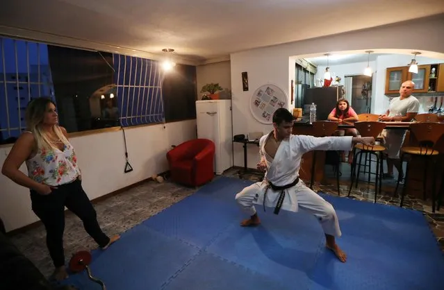 Venezuela team karateka Ricardo Perez during a training session at home with his family, following the outbreak of the coronavirus disease (COVID-19), Caracas, Venezuela, May 8, 2020. (Photo by Manaure Quintero/Reuters)