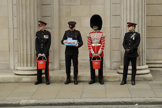 Members of the British military's Honourable Artillery Company collect donations for the annual poppy appeal ahead of Armistice Day outside the Bank of England in the City of London, Thursday, November 2, 2017. There is speculation that the Bank of England is poised to raise its main interest rate later Thursday for the first time in a decade to keep a lid on a rise inflation caused by Brexit. (Photo by Matt Dunham/AP Photo)