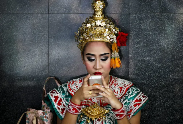 A Thai dancer performer uses her mobile phone at the Erawan Shrine in Bangkok, Thailand, 16 August 2016. A bomb exploded at the Erawan Shrine on 17 August 2015 and killed 20 people and injured more than 100 while two foreign bomb suspect were arrested and under trial by the Thai military court. A series of bomb attacks on 12 August 2016 in major popular tourist towns killing four people and more than 20 people injured including foreign tourists will shake Thailand's tourism industry. (Photo by Rungroj Yongrit/EPA)