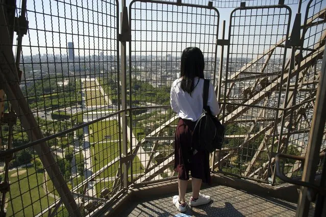 A visitor enjoys the view as she climbs the stairs of the Eiffel Tower, in Paris, Thursday, June 25, 2020. The Eiffel Tower reopens after the coronavirus pandemic led to the iconic Paris landmark's longest closure since World War II. (Photo by Thibault Camus/AP Photo)
