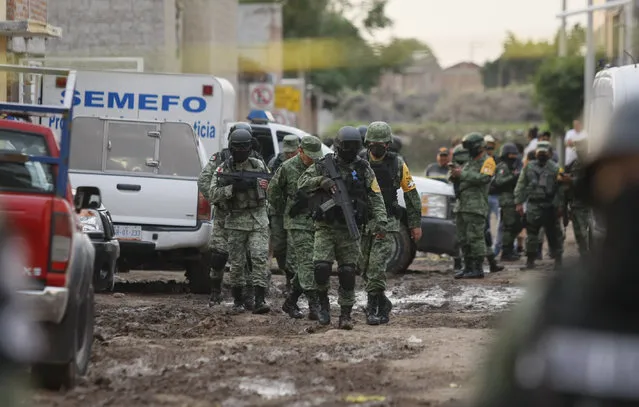 Members of the national guard walk near an unregistered drug rehabilitation center in Irapuato, Mexico, Wednesday, July 1, 2020, after gunmen burst into the facility and opened fire. More than 20 people were killed and several were wounded in the attack, authorities said. (Photo by Mario Armas/AP Photo)