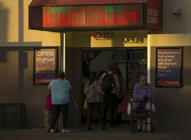 Customers wait in line to exchange currencies in the border town of San Ysidro, California September 2, 2015. Picture taken September 2, 2015. (Photo by Mike Blake/Reuters)