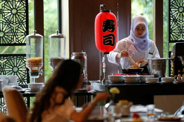 A Muslim employee cooks as a visitor has breakfast at the Al Meroz hotel in Bangkok, Thailand, August 29, 2016. (Photo by Chaiwat Subprasom/Reuters)