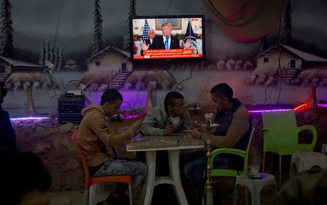 Palestinians play cards during U.S. President Donald Trump's televised speech in the West Bank City of Nablus, Wednesday, December 6, 2017. Defying dire, worldwide warnings, President Donald Trump on Wednesday broke with decades of U.S. and international policy by recognizing Jerusalem as Israel's capital. (Photo by Majdi Mohammed/AP Photo)