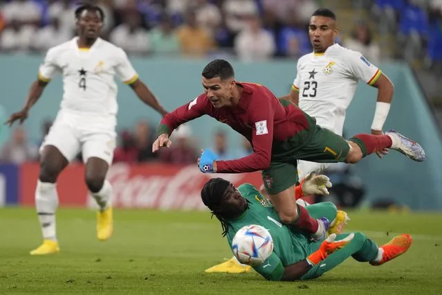 Portugal's Cristiano Ronaldo, up, falls over Ghana's goalkeeper Lawrence Ati-Zigi during the World Cup group H soccer match between Portugal and Ghana, at the Stadium 974 in Doha, Qatar, Thursday, November 24, 2022. (Photo by Darko Bandic/AP Photo)