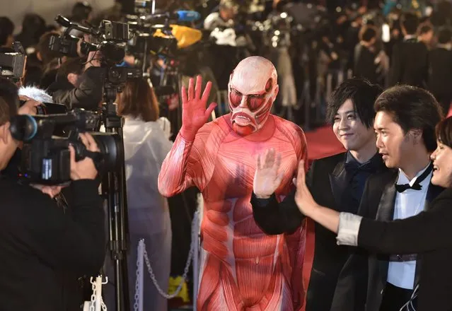 Japan's animation character “Attack on Titan” (C) poses on the red carpet for the 27th Tokyo International Film Festival opening ceremony in Tokyo on October 23, 2014. The Tokyo International Film Festival opens on October 23 with its focus heavily on Japanese animated movies and with cult superhero “Ultraman” set to swoosh down the red carpet with Prime Minister Shinzo Abe. (Photo by Kazuhiro Nogi/AFP Photo)