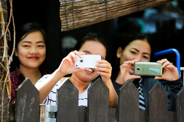 People get a look at U.S. President Barack Obama's traveling media and entourage as he walks in Luang Prabang, Laos September 7, 2016. (Photo by Jonathan Ernst/Reuters)