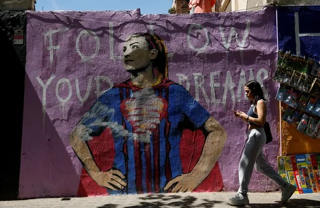 A woman walks past a mural of FC Barcelona soccer player Alexia Putellas in Barcelona, Spain on May 12, 2022. (Photo by Albert Gea/Reuters)