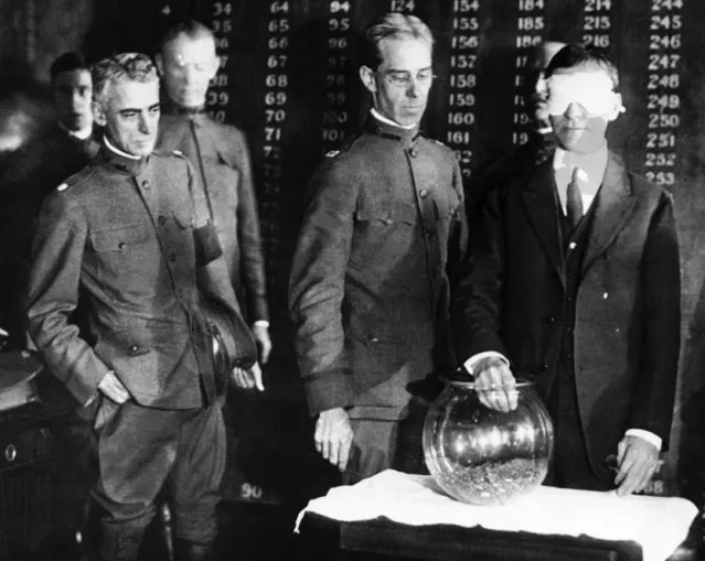 Secretary of war Henry Stimson will draw from this goldfish bowl on October 29, 1917, the first number in a nationwide lottery to determine the order of calling men for military training under selective service. Secretary of war Newton D. Baker, right, in this scene from June 27, 1918, draws the first number in the world war 2nd draft. (Photo by AP Photo)