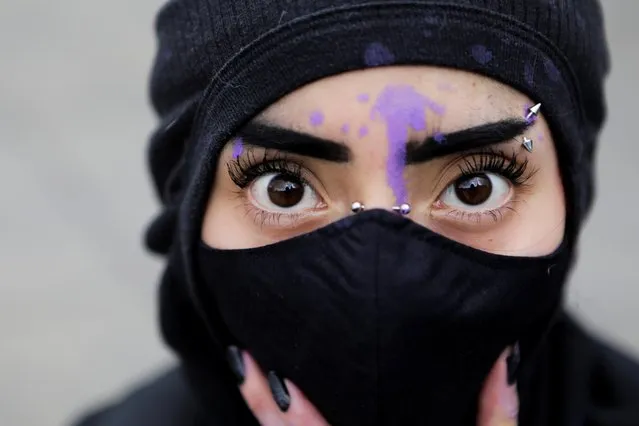 A masked woman poses for a picture during a march demanding justice for the victims of gender violence and femicides in Mexico City, Mexico on August 16, 2020. (Photo by Raquel Cunha/Reuters)