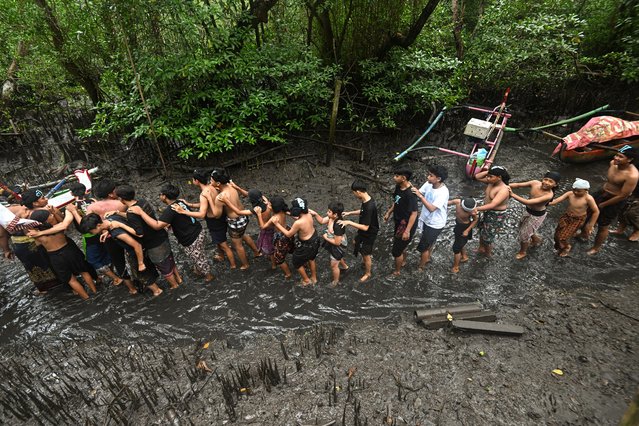 People take part in a mud bath tradition, known as Mebuug-buugan, held a day after Nyepi – the Balinese “Day of Silence” – aimed at neutralising bad traits, in Kedonganan village, near Denpasar on Indonesia's resort island of Bali on March 30, 2025. (Photo by Sonny Tumbelaka/AFP Photo)