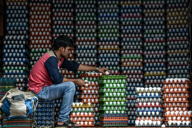 A man arranges eggs for delivery in Mumbai on August 19, 2020. (Photo by Indranil Mukherjee/AFP Photo)