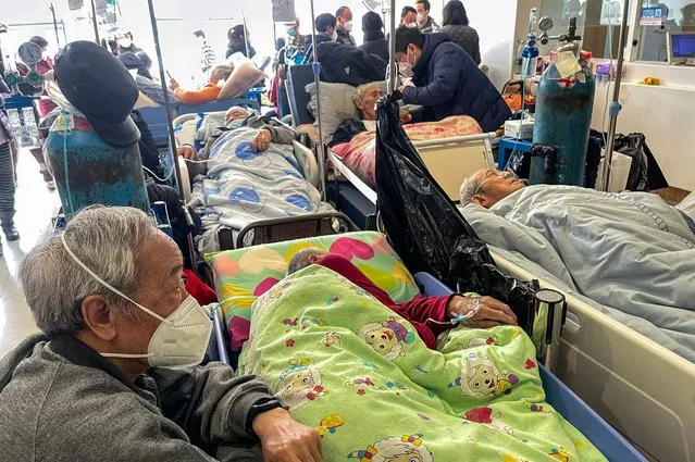 Patients on stretchers are seen at Tongren hospital in Shanghai on January 3, 2023. A senior doctor at Shanghai's Ruijin Hospital has said 70 percent of the megacity's population may have been infected with Covid-19 during China's huge surge in cases, state media reported on January 3. (Photo by Hector Retamal/AFP Photo)