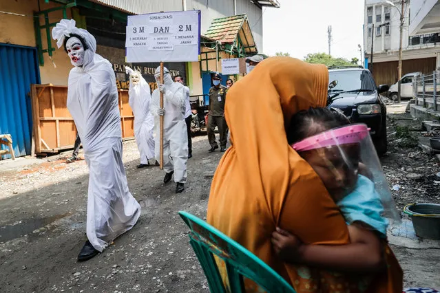 Officials dressed up as “pocong” or shroud ghosts march during a COVID-19 awareness campaign at a market in Tangerang, outskirt of Jakarta, Indonesia, 16 September 2020. Indonesia has recorded over 200,000 cases of COVID-19 since the pandemic started, with nearly 9,000 deaths, the highest number in Southeast Asia. (Photo by Mast Irham/EPA/EFE)