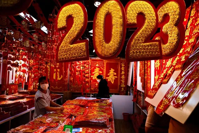 A vendor sorts decorations for Chinese Lunar New Year at a market selling Spring Festival ornaments ahead of the Chinese Lunar New Year festivity, in Beijing, China on January 7, 2023. (Photo by Tingshu Wang/Reuters)
