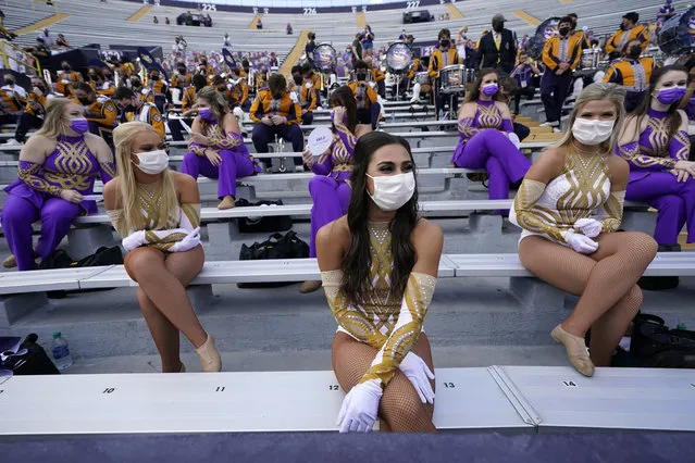 Members of the LSU Golden Girls dance team sit spaced apart wearing masks, under COVID-19 restrictions, requiring social distancing and masks, before an NCAA college football game between the LSU and the Mississippi State in Baton Rouge, La., Saturday, September 26, 2020. (Photo by Gerald Herbert/AP Photo)