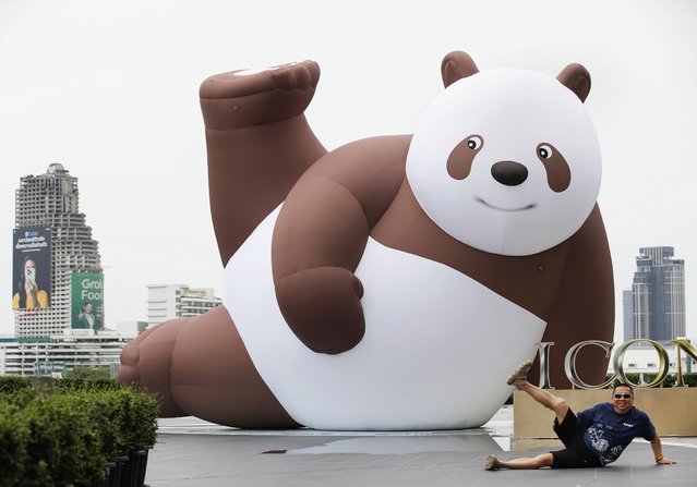A Chinese tourist poses for a photograph with an inflatable artwork entitled Panda Seven, created by Chinese artist Leo Huang, at the Yimu Art Exhibition at ICONSIAM shopping mall in Bangkok, Thailand, 03 July 2025. The Yimu Art Exhibition, in collaboration with China's Yimu Art Studio, showcases the inflatable sculpture Panda Seven by Leo Huang to celebrate the 50th anniversary of Thai-Chinese diplomatic relations. (Photo by Rungroj Yongrit/EPA)