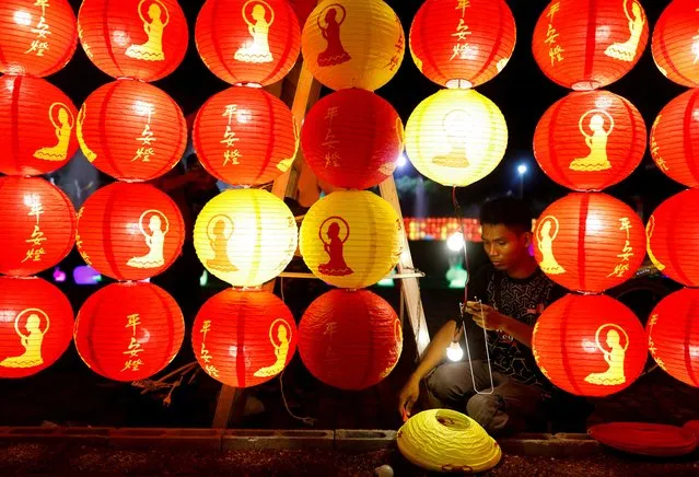 A worker installs lanterns ahead of Chinese Lunar New Year at Fo Guang Shan Dong Zen Buddhist Temple in Jenjarom, Selangor, Malaysia on January 13, 2023. (Photo by Hasnoor Hussain/Reuters)