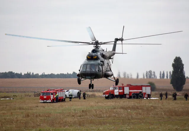 Ukrainian military helicopter flies over fire vehicles during a rescue training exercise at Boryspil International Airport outside Kiev, Ukraine, September 27, 2016. (Photo by Valentyn Ogirenko/Reuters)