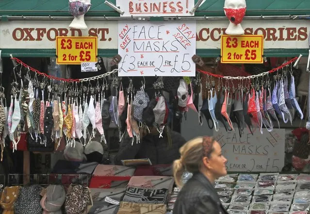 A shop sells face masks on Oxford Street in London, Tuesday, October 13, 2020. Unemployment across the U.K. rose sharply higher in August which is a clear indication that the jobless rate is set to spike higher when a government salary-support scheme ends this month and new restrictions are imposed on local areas to suppress a resurgence of the coronavirus. (Photo by Frank Augstein/AP Photo)
