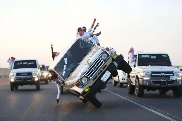 Saudi youths demonstrate a stunt known as “sidewall skiing” (driving on two wheels) in the northern city of Tabuk, in Saudi Arabia December 3, 2014. (Photo by Mohamed Al Hwaity/Reuters)