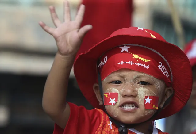 A child waves his hand at people supporting a campaign of Myanmar leader Aung San Suu Kyi's National League for Democracy (NLD) party during a rally for next month's general election, Wednesday, October 21, 2020, in Naypyitaw, Myanmar. (Photo by Aung Shine Oo/AP Photo)