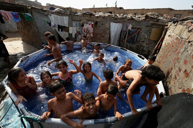 Children play in a portable swimming pool, offering respite from the summer heat for residents who are unable to afford travelling to the beaches along the Mediterranean Sea to cool off, during a heat wave, in Manshiyet Nasser shanty town, Al-Duwayqa, in Cairo, Egypt, on August 11, 2025. (Photo by Mohamed Abd El Ghany/Reuters)