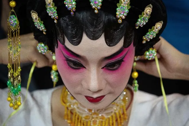 An actress prepares herself before performing in a Chinese Opera during the celebrations of God Tou Tei (the God of Earth) in Macau, China, February, 20, 2023. (Photo by Eduardo Leal/AFP Photo)
