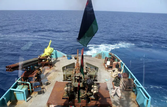 A member of Libyan coastguard walks n a ship as they help forces allied with the U.N.-backed government fighting Islamic State militants, off the coast of Sirte, Libya October 6, 2016. Picture taken through glass. (Photo by Hani Amara/Reuters)