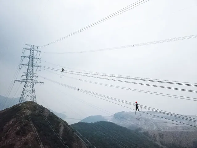 Aerial photo shows technicians of State Grid Zhejiang Electric Power Company checking power transmission lines to make sure the stable operation of local power supply in Zhoushan, east China's Zhejiang Province, October 23, 2020. (Photo by Xinhua News Agency/Rex Features/Shutterstock)