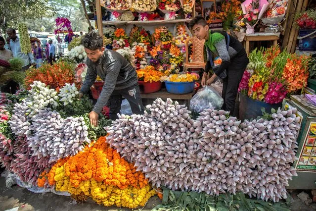 Flower vendors arranges roses for sale ahead of Spring Festival and Valentine's Day, in Dhaka, Bangladesh 13 February 2023. The Bashanta Utshab, or Spring Festival, is a local traditional festival which marks the beginning of the Spring Season while young people also celebrate it along with Valentine's Day. With both, the Spring Festival and Valentine’s Day, flower vendors are expecting massive sales, especially of roses. (Photo by Monirul Alam/EPA/EFE)
