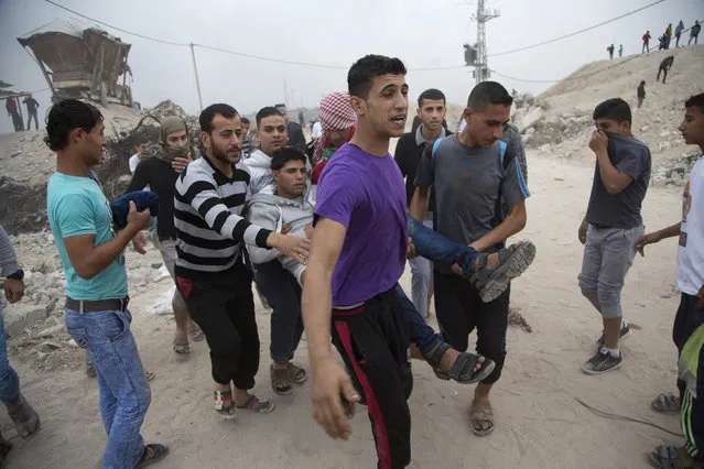 Palestinian protesters evacuate a wounded youth during clashes with Israeli soldiers on the Israeli border Eastern Gaza City, Friday, November 6, 2015. (Photo by Adel Hana/AP Photo)