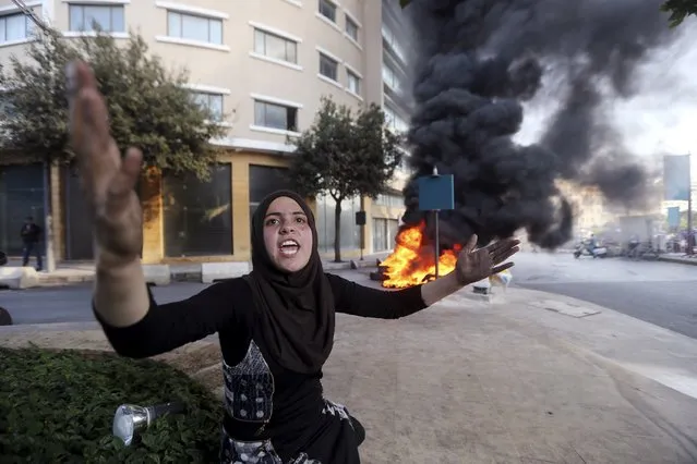 Wadha al-Sayyed, wife of captive Lebanese soldier Khaled Moqbel, protests for his release and government action, near burning tyres blocking a road in Beirut, December 15, 2014. More than two dozen members of the Lebanese security forces are being held by Sunni Islamists. (Photo by Hasan Shaaban/Reuters)