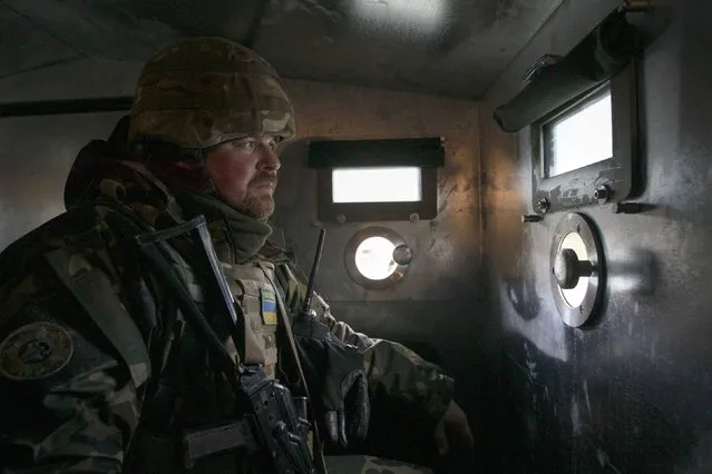 A Ukrainian serviceman keeps watch from an armored personnel carrier (APC) as he patrols the road in Donetsk region, December 24, 2014. (Photo by Valentyn Ogirenko/Reuters)