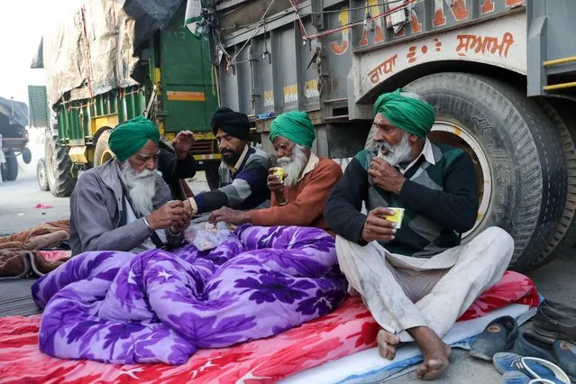 Farmers have tea and breakfast in the early morning at the site of a protest against the newly passed farm bills, at Singhu border near Delhi, India December 2, 2020. (Photo by Anushree Fadnavis/Reuters)